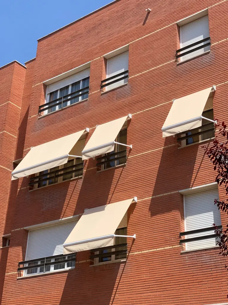 Toldo de punto recto en la ventana de un edificio de ladrillo