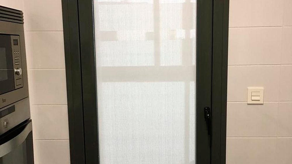 Puerta de cocina con un gusanillo de tejido screen Helios blanco, plano sobre el cristal