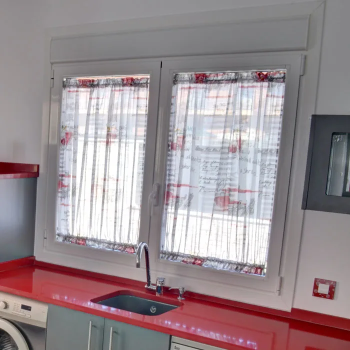 Gusanillo fruncido de visillo estampado en la ventana de una cocina