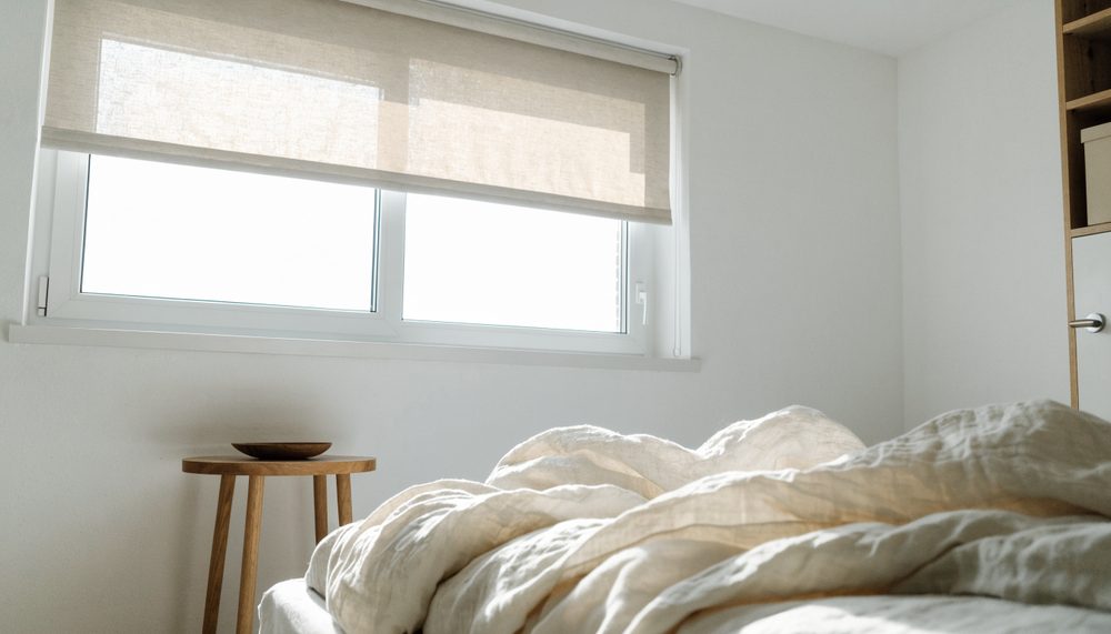 Dormitorio con estor enrollable sobre la ventana