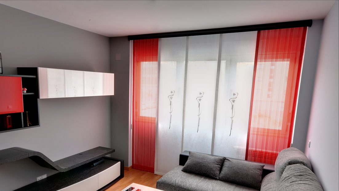 Paneles japoneses bordados en blanco y rojo en el ventanal de un salón