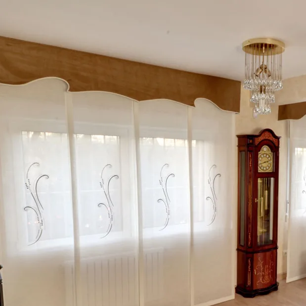 Paneles japoneses bordados en blanco en el ventanal de un salón