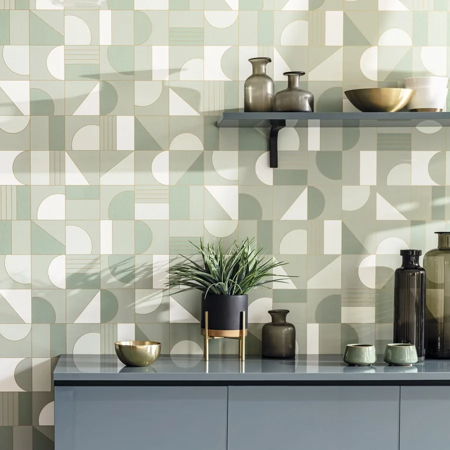 Pared con papel pintado geométrico verde sobre un mueble gris