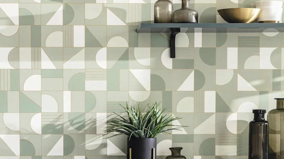 Pared con papel pintado geométrico en verdes, una repisa y un mueble gris