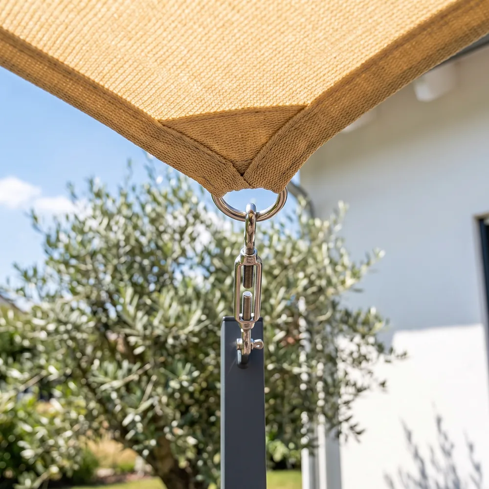 Esquina de un toldo vela tensada con herrajes de acero inoxidable a un poste