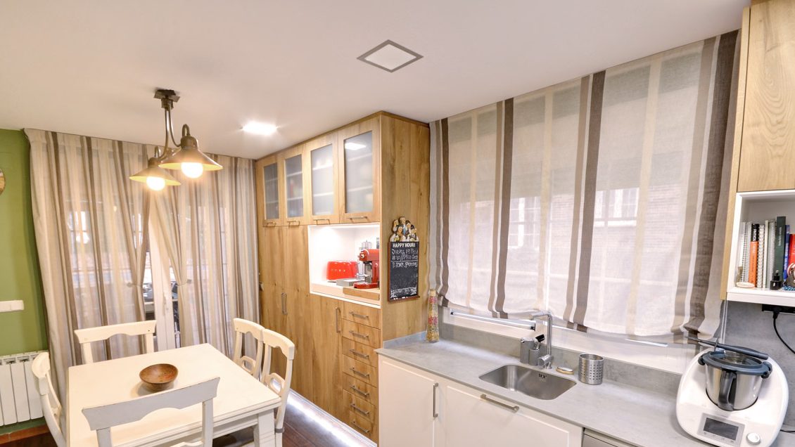 Cocina con cortinas de tablas y estores de paquete instalados por nosotros