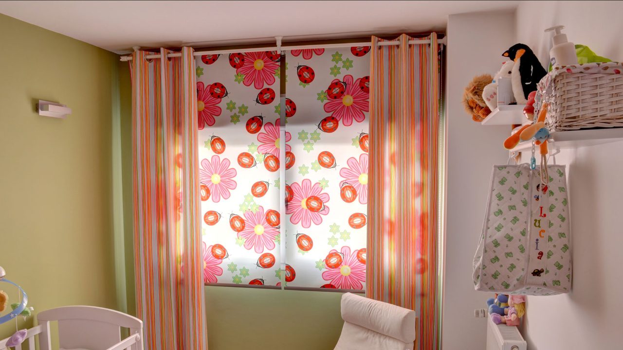 Habitación infantil con cortinas de flores y un estor estampado