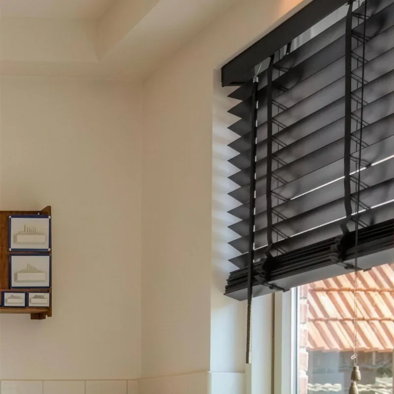 Venecianas de madera negra en la ventana de una cocina