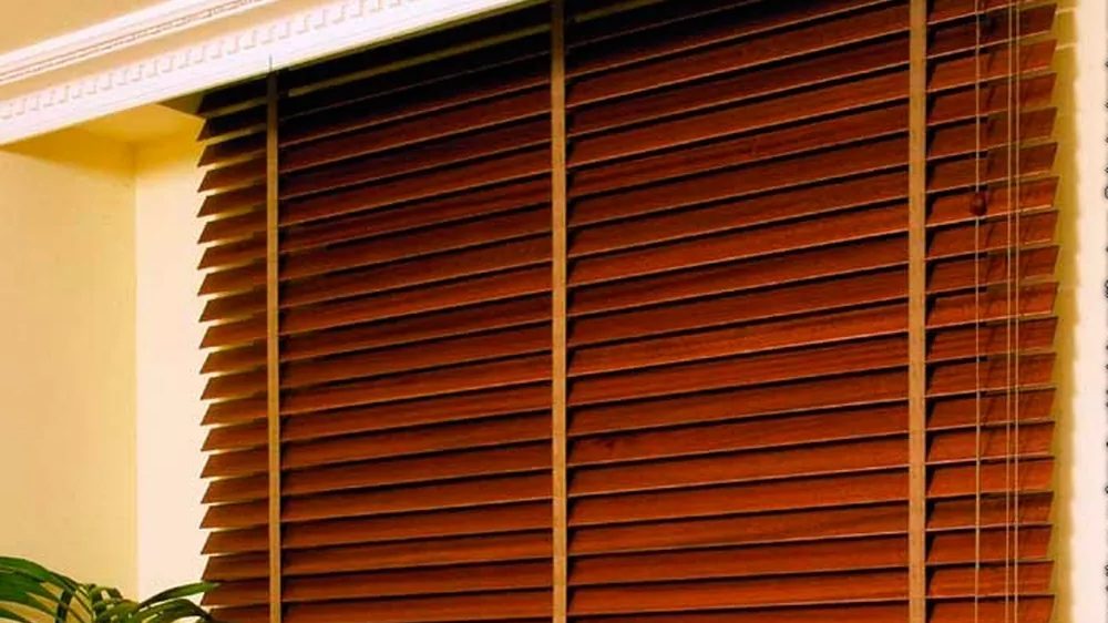Cocina con venecianas de madera negra en la ventana