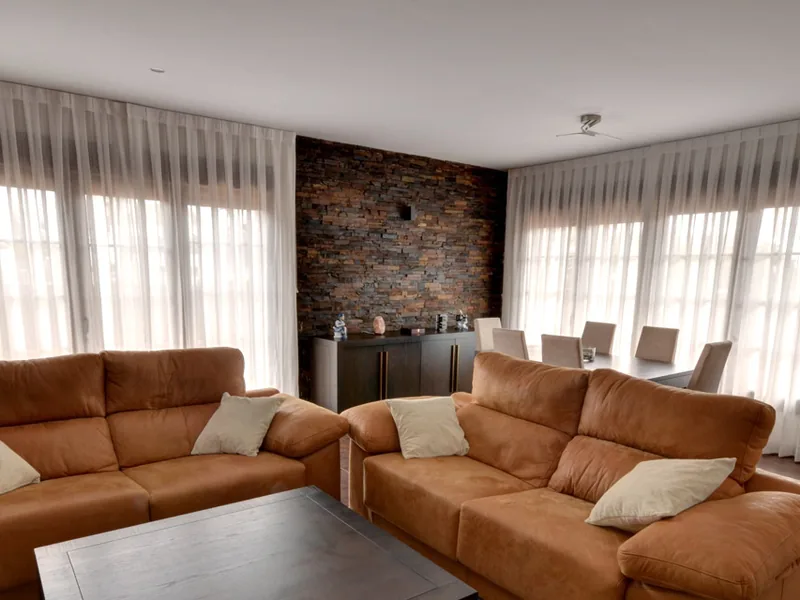 Salón con cortinas de tablas blancas en dos ventanales