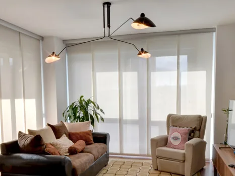 Salón con paneles japoneses blancos delante del ventanal