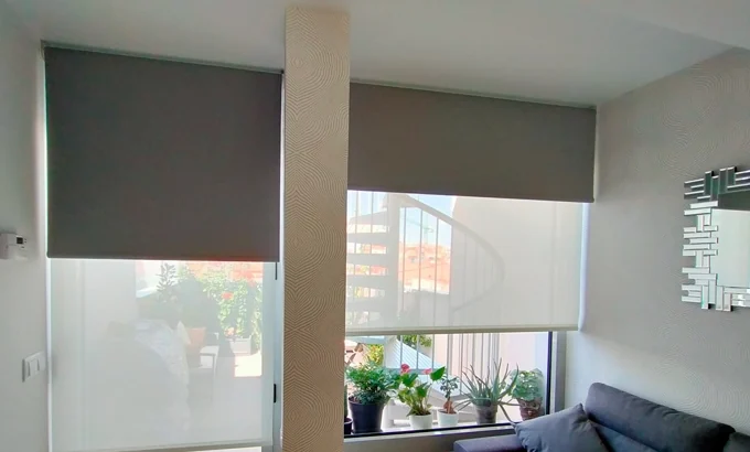 Salón con columna empapelada y estor doble
