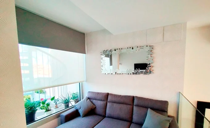 Salón con papel pintado y estores enrollables