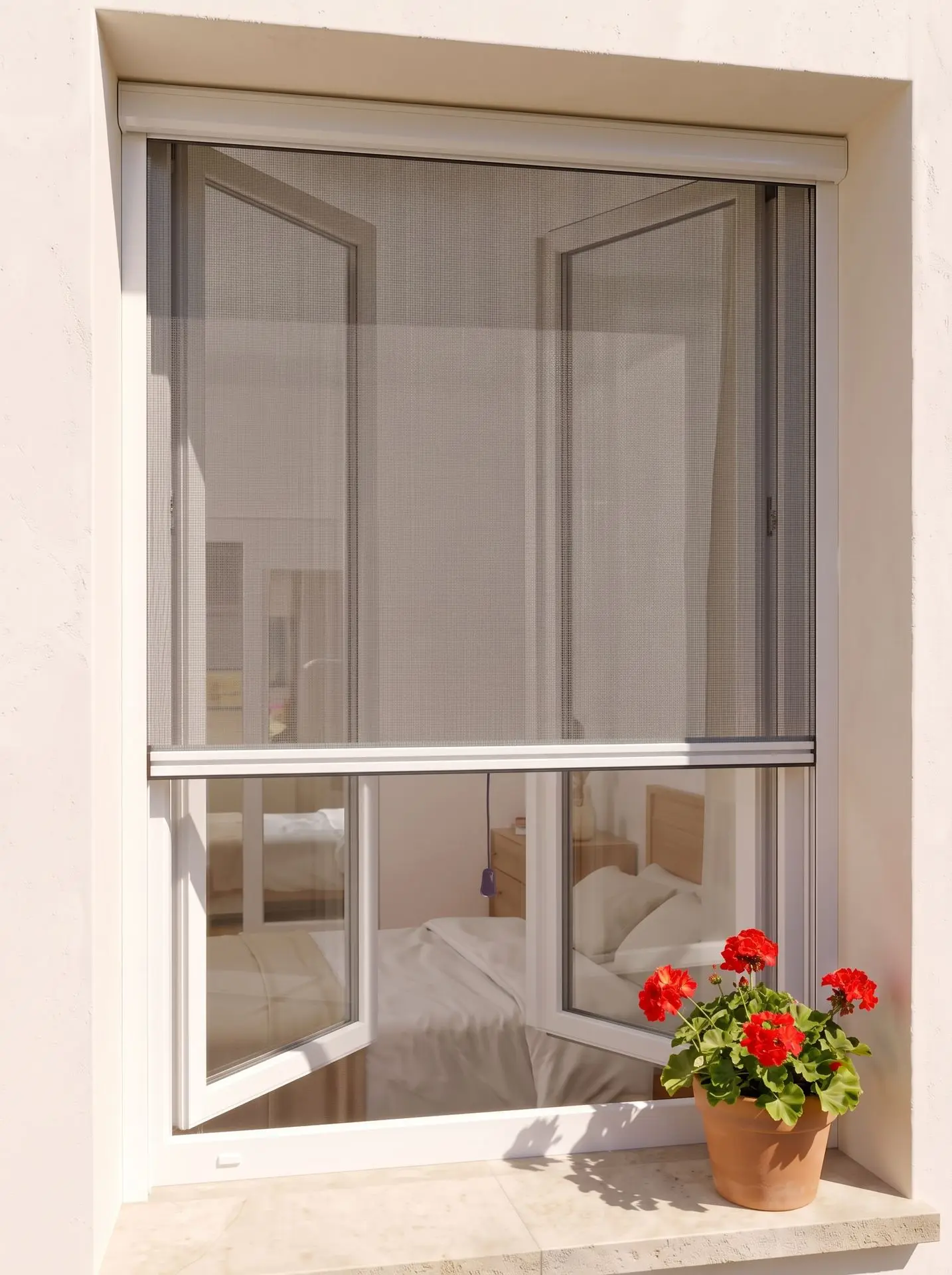 Mosquitera enrollable en una ventana, instalada por fuera, con el cajón arriba y bajada hasta la mitad